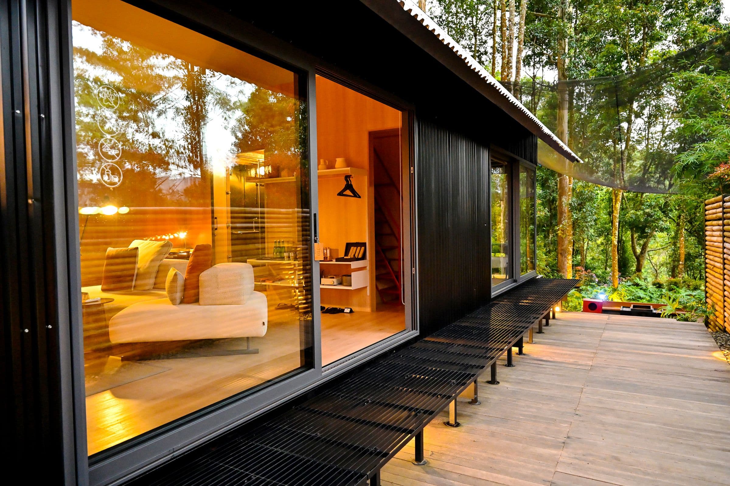 Modern glass and timber retreat surrounded by greenery